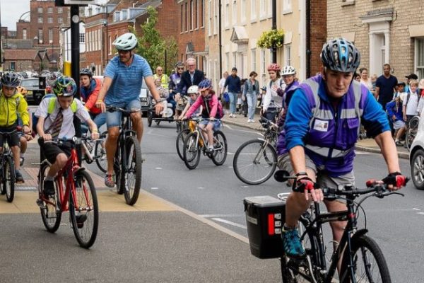 A group of students and parents cycling to school together.