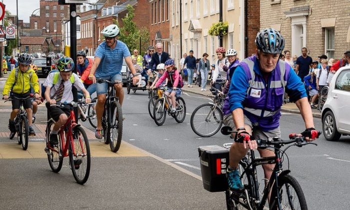 A group of students and parents cycling to school together.